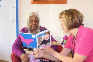 Service user at Bradbury Wellbeing Centre looking at the book of poems she contributed to